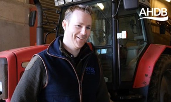 a person smiling in front of a tractor